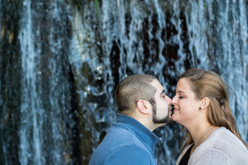 Fototapeta premium Paar küsst sich vor Wasserfall