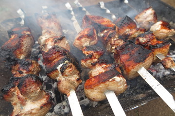 Pork shashlyk (shish kebab) roasting on skewers in the garden