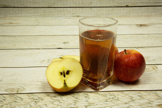 A glass of apple juice and apples on wooden background Vintage