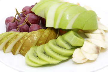 a large plate of sliced fruit on white background