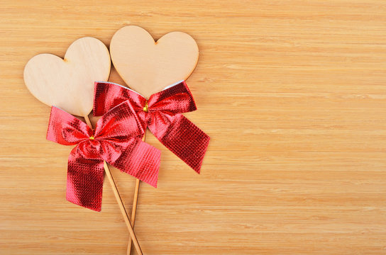 Heart with red bow on wooden background