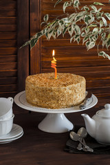Honey cake , tea cups, teapot and flower on brown wooden table. Tea time. Vintage and rustic style