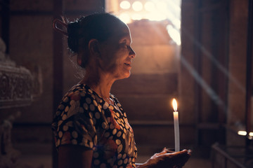 Burmese woman praying with candle light