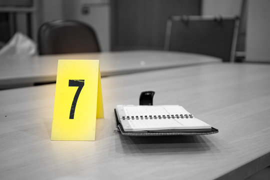 yellow evidence number pad and evidence on table in crime scene