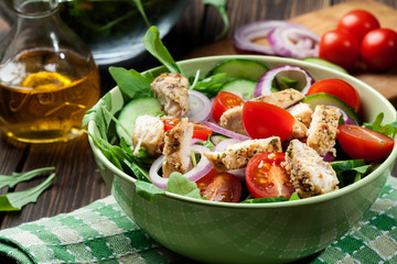 Fresh salad with chicken, tomatoes and arugula on plate