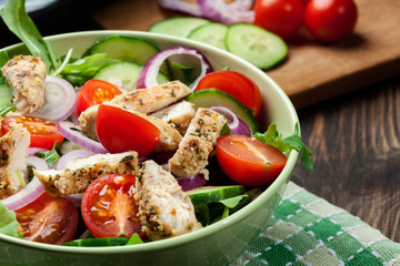 Fresh salad with chicken, tomatoes and arugula on plate