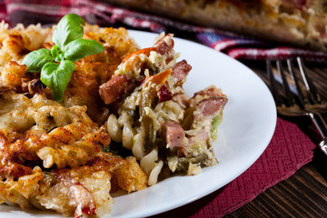 Portion of fusilli pasta casseroles, sausages and zucchini