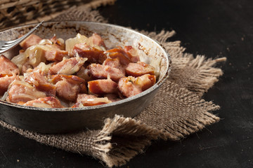 Pieces of sausage fried with onions