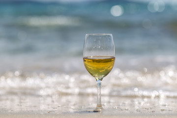 Tall wine glass on sand