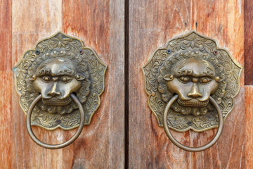 Old metal ornamental brass door handle close-up.