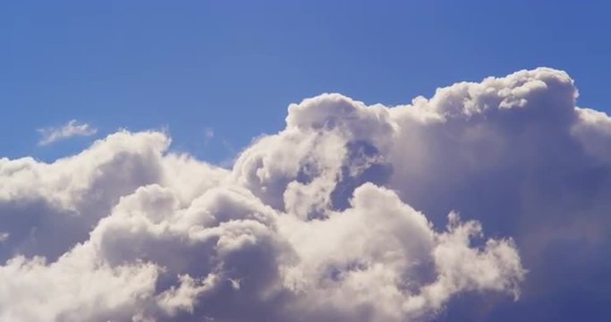 4k timelapse of dramatic rolling cumulus clouds against blue sky