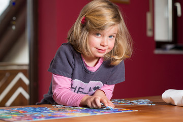 little girl doing a jigsaw puzzle