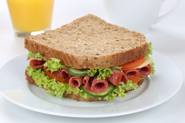 Sandwich Toast zum Frühstück belegt mit Salami und Saft