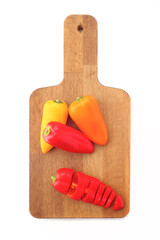 group of colored peppers on wooden board