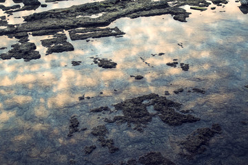 Clouds reflecting into the sea at sunset