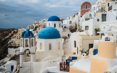 Fototapeta na wymiar Blue-domed Greek Orthodox churches in Oia town on the island of Santorini, Greece