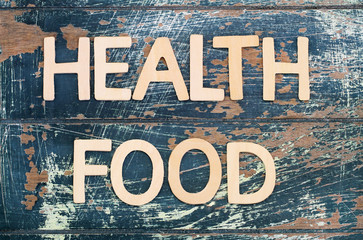Health food written with wooden letters on rustic surface
