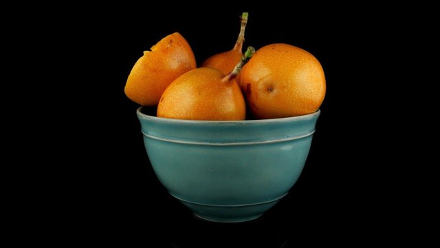 Passion fruit maracuja granadilla on ceramic blue bowl, black background.