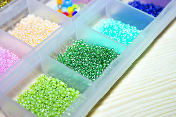 sparkling multicolored beads in boxes. Background blurry