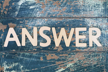 Word answer written on rustic wooden surface
