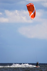 Kitesurfer with splendid orange kite