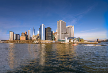 Fototapeta na wymiar Lower Manhattan skyline panorama over East River with reflection