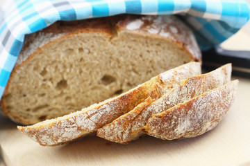 Traditional rustic rye bread on wooden board, closeup
