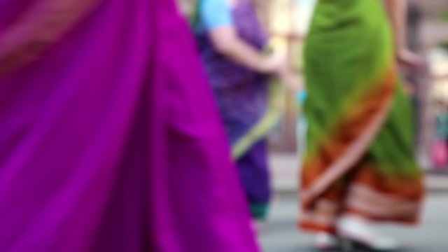 Women in Hindu traditional colorful costumes, dancing on the street, defocused video