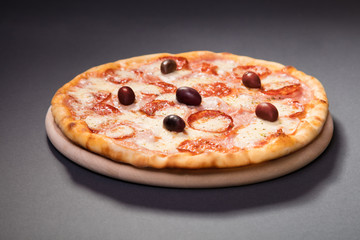 Hot spicy pizza with sausage, olives and mozzarela cheese served