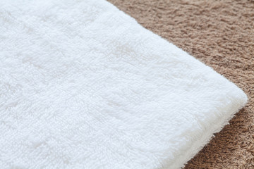 Fototapeta na wymiar White clean towel on brown towel background