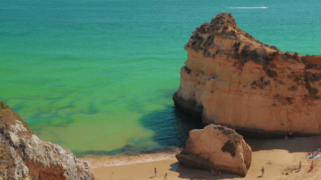 A static top-down view of a rocky beach with tourists in the Algarve, Portugal

