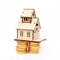 Dream house on the pile of golden coins isolated in white