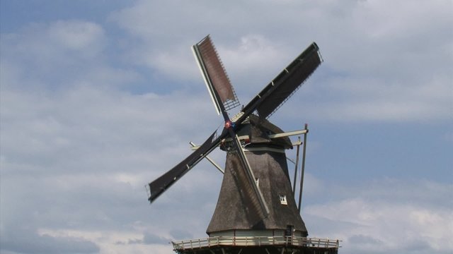 Dutch Windmill in operation. The gallery or deck surrounding the floor outside the tower provides access around the tower mill and sails. The Vilsteren windmill dates from 1858.