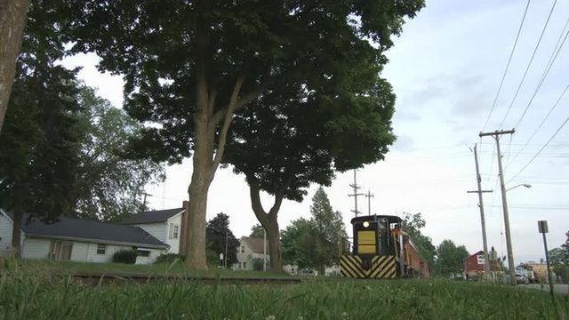 Diesel locomotive pulling a train on a railway line in the Mid West, USA. Wide view, low viewpoint with telegraph poles visible.  Ultra high definition, 4K.