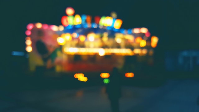 Blurred background, illuminated lights carousel with people