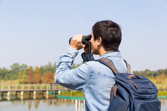 The Back Rear Of Man Using Binoculars For Birdwatching