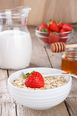 Healthy cereal with milk, honey and strawberry