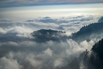 Fototapeta na wymiar Emerging peaks among the clouds