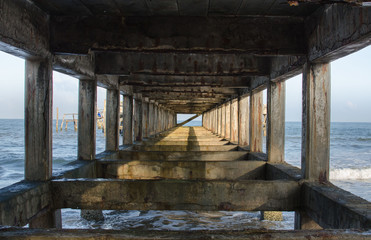 Under construction old cement bridge into the sea, Thailand