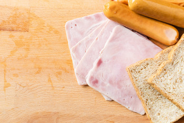 Ham,sausages  and bread on a wooden cutting board