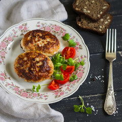 pork cutlets  with vegetable salad on dark wooden surface.  Delicious lunch