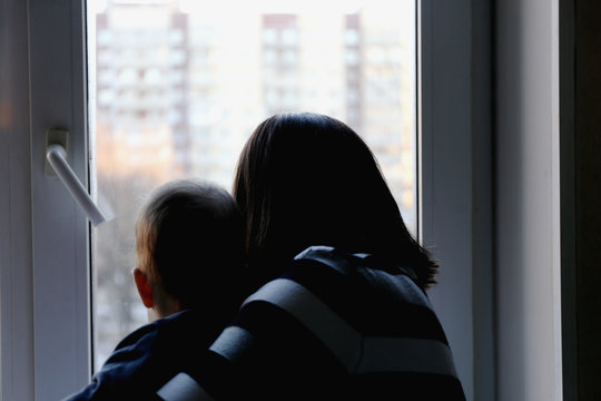 Mom With A Child Looking Out The Window