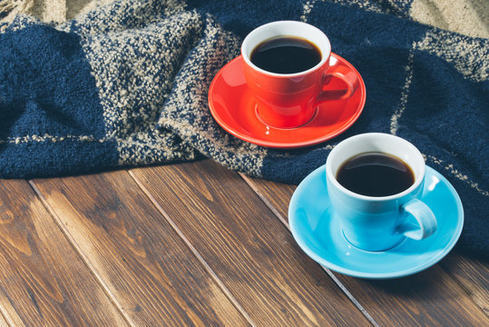 Blanket and two cups of coffee on wooden floor