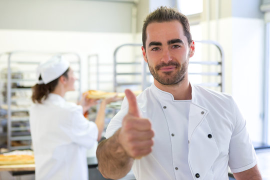 Young attarctive baker working at the bakery