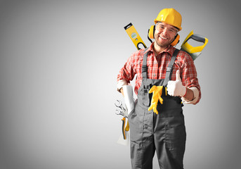 Builder in yellow helmet, protective glasses and working clothes