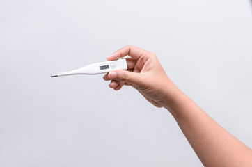 Hand holding digital thermometer for fever measurement on white