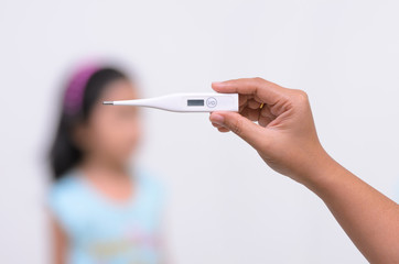 Hand holding digital thermometer for fever measurement with blur