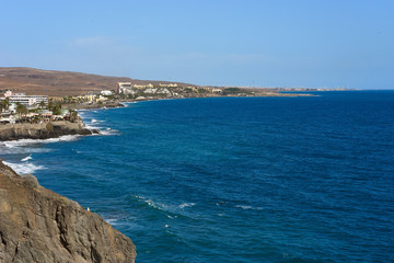 View down the cliffs of Gran Canaria on the wide atlantic ocean / green and blue water under great...