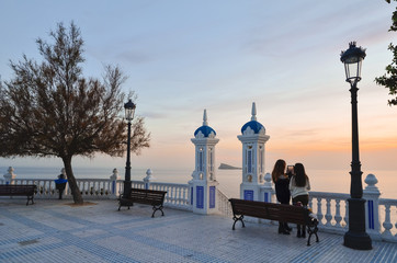 Pareja de mujeres tomando una fotografía al atardecer en Benidorm