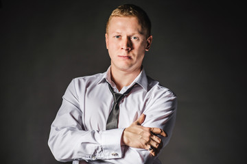 Portrait of serious elegant handsome young man in classic suit toasting with ring. Undo shirt